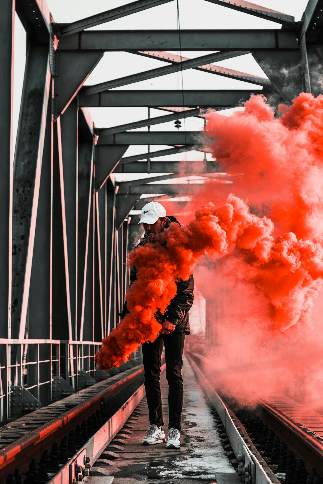 A rep walking a steel bridge trailing orange smoke